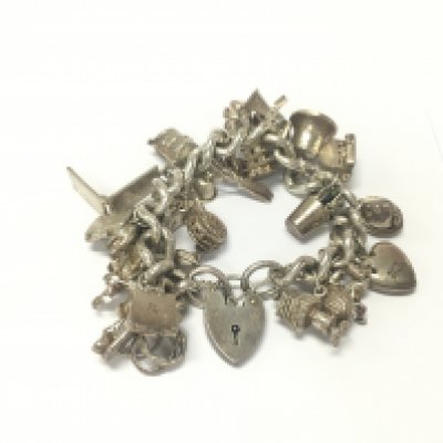 A heavy silver charm bracelet set with a large number of silver charms. Approximately 140g