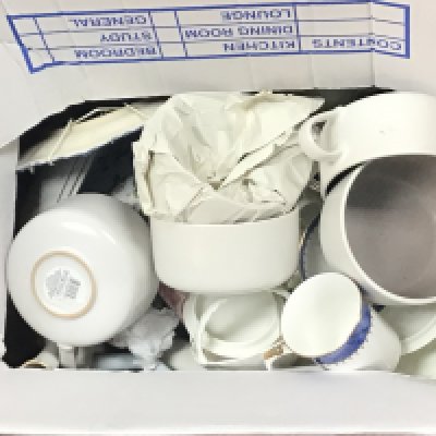 Two boxes containing decorative blue and white ceramics and other ceramics including a Lladro style figure.