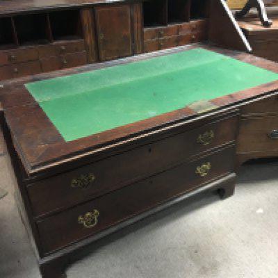 A George III mahogany bureau with a well fitted with small drawers and hidden compartments above four drawers on bracket feet. Width