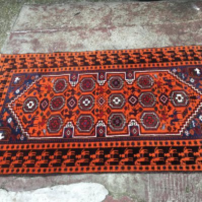 An orange tribal design rug with depictions of pheasants and horses with patterned design. Dimensions 98x114mcm. This lot cannot be posted