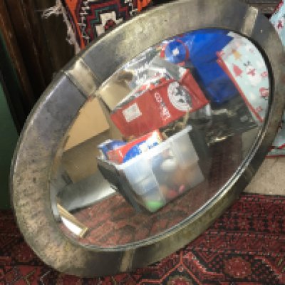 An oval mirror , 84 cm wide.