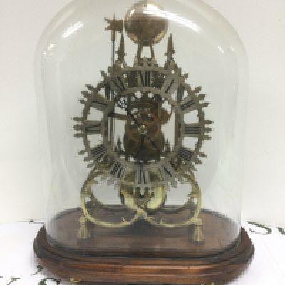 A skeleton clock under a glass dome. Shipping category D.