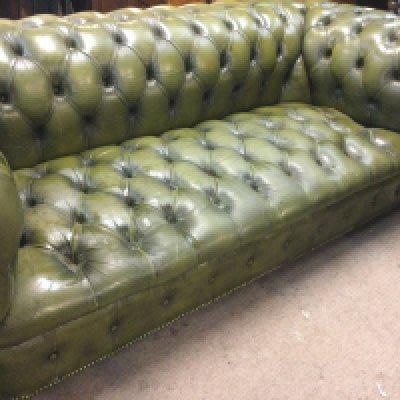 A green leather chesterfield sofa with button back and seat 198 cm x 90 cm .