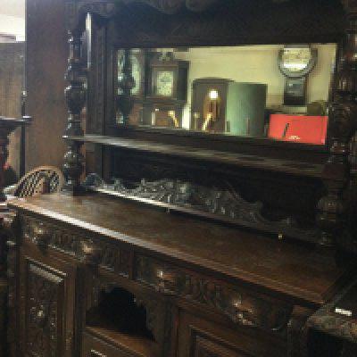 A oak mirror back sideboard the raised back above two drawers and cupboards under on ball shaped feet . 220 cm x 150 cm .