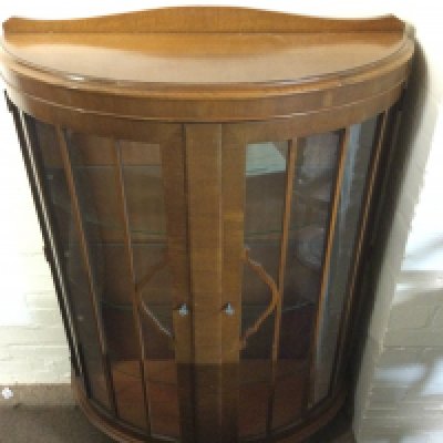 A bow fronted display case. 87cm wide 36 deep 128cm tall.