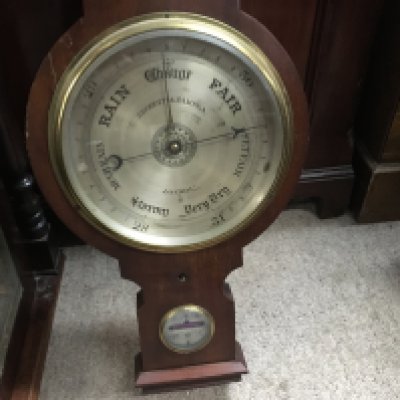A mahogany stick barometer and one other barometer.