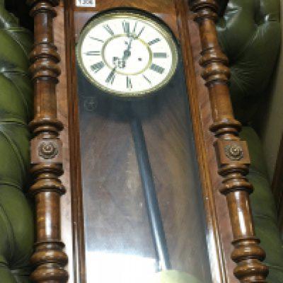 A walnut case double weight wall clock with visible pendulum and two other wall clocks .