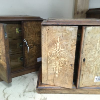 A pair of walnut small collectors cabinets with a pair of inlaid doors enclosing three drawers