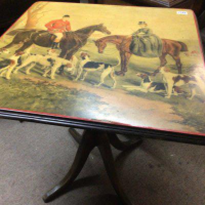 A Mahogany occasional table the top with an image of a hunt.
