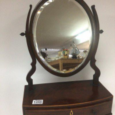 A late George III mahogany dressing mirror with an oval mirror above a single drawer on ogee bracket feet.