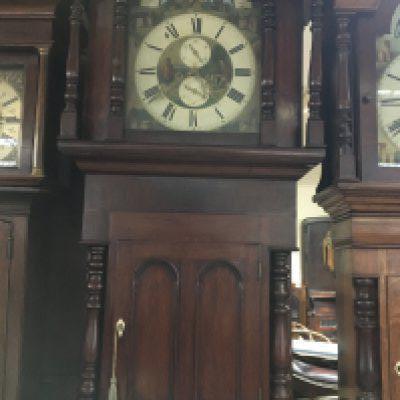 A Victorian mahogany long case clock the Arched painted dial with moon roller second subsidiarie dial and Roman numerals.