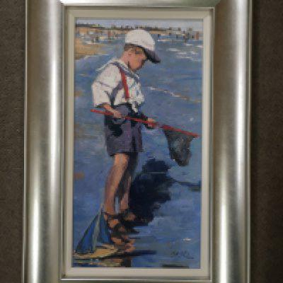A silver framed limited edition print depicting boy with toy sailing boat and net, by Sheree Valentine Daines