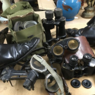 A box containing militarily items of interest including two pairs of binoculars, a sextant, gas mask, Google's etc