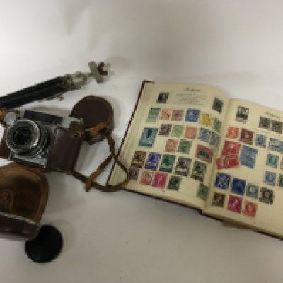 A stamp album containing world stamps The Postboy stamp album and a vintage camera a Japanese Beaumat serial number S11341.