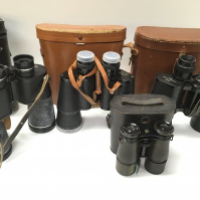 A collection of binoculars. Postage C
