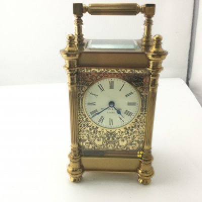 A Mappin and Webb carriage clock with floral fretwork frontage.