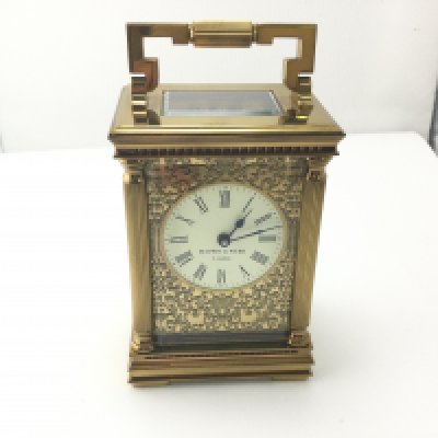 A Mappin and Webb carriage clock with floral fretwork frontage.