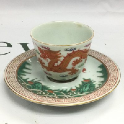 An oriental tea bowl and saucer with hand painted decoration of dragons and bats and having four character marks to base. Shipping category D.