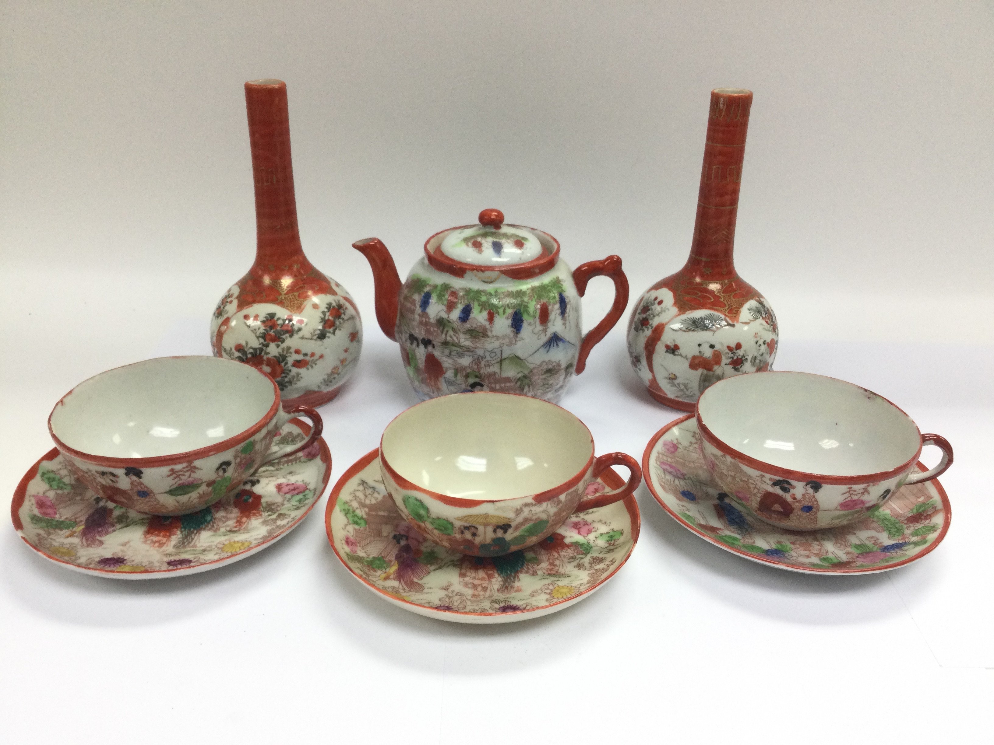 A small collection of Oriental ceramics comprising a pair of bud vases, teapot and three cups and saucers.