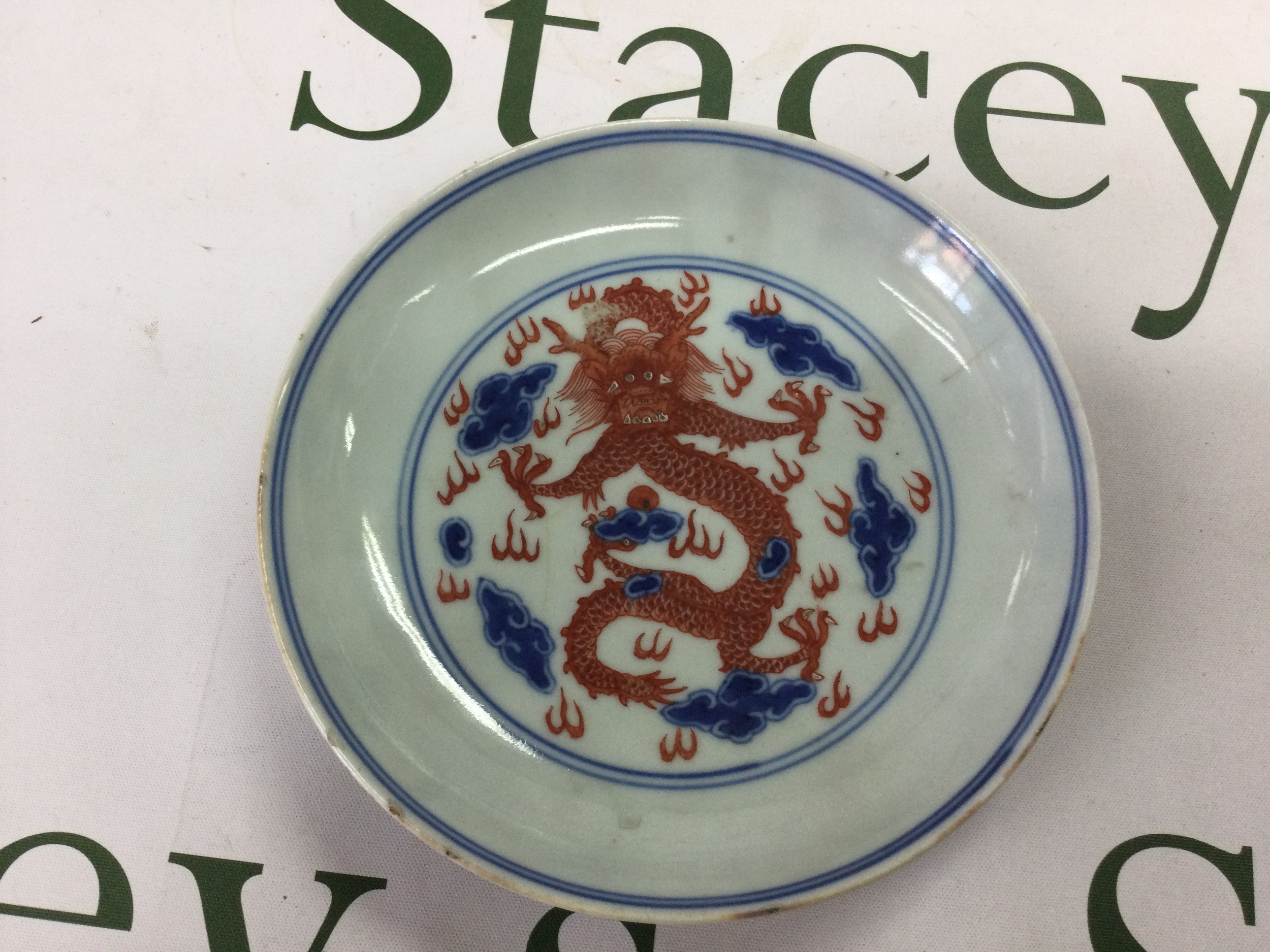 Kang Xi vase and bowl with bubbled glaze and a Qiang Long marked Dragon plate. bowl with raised floral design to the interior and two concentric blue rings to inside the rim, bowl decorated with floral motifs and base marked with blue character mark the glaze under a loupe has a Yong Zheng bubbled appearance 133mm x 65mm clear ring sound when flicked, minor flitting to the rim. vase decorated with birds amongst prunus branches, missing lid bubbled glaze and no damage 15 cm x 11cm. Dragon plate brightly decorated with red Dragon amidst clouds and fire within concentric blue circles, verso decorated with two further Dragons chasing the pearl of wisdom, central to the base a Qiang Long seal in blue, 15.5 cm width, minor chips to the rim. And hairline crack to the centre but rings clear when flicked.