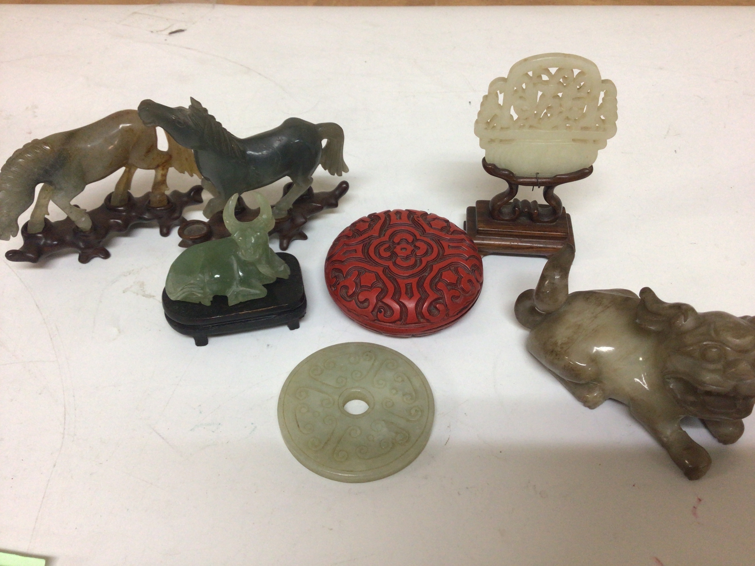 A Collection of Chinese jade and other items early 20th century a miniature screen in a hardwood stand a temple dog horses on hardwood stands one damaged. 