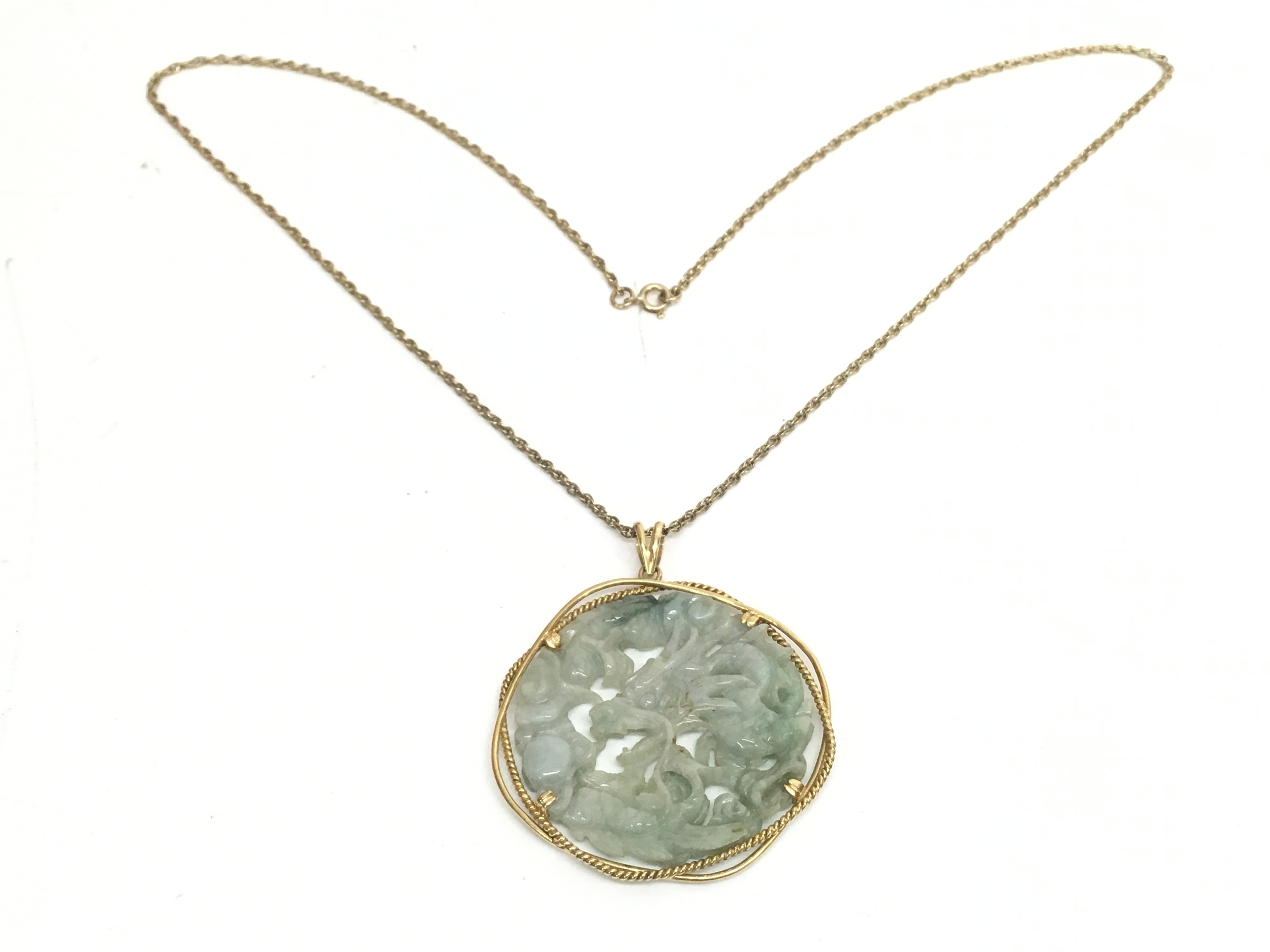 A Chinese 14ct gold mounted jade dragon pendant on a 9ct gold chain (30cm long). 27.5g total weight 