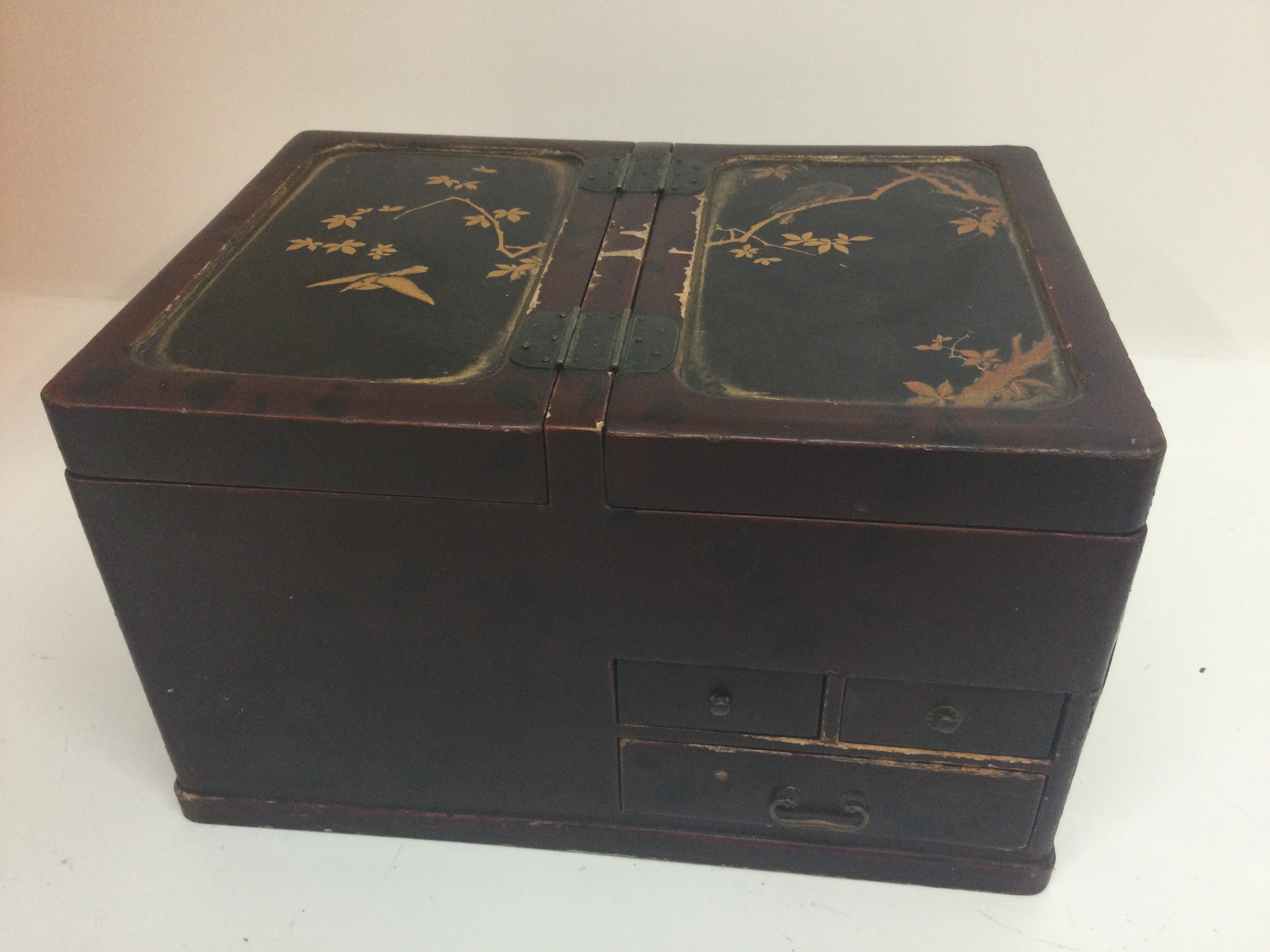 An East Asian style jewellery box, the top panels are decorated with Classic easy Asian motifs featuring gold painted illustrations of birds perched on flowering tree branches. 30cm wide,17cm tall, 22cm long 