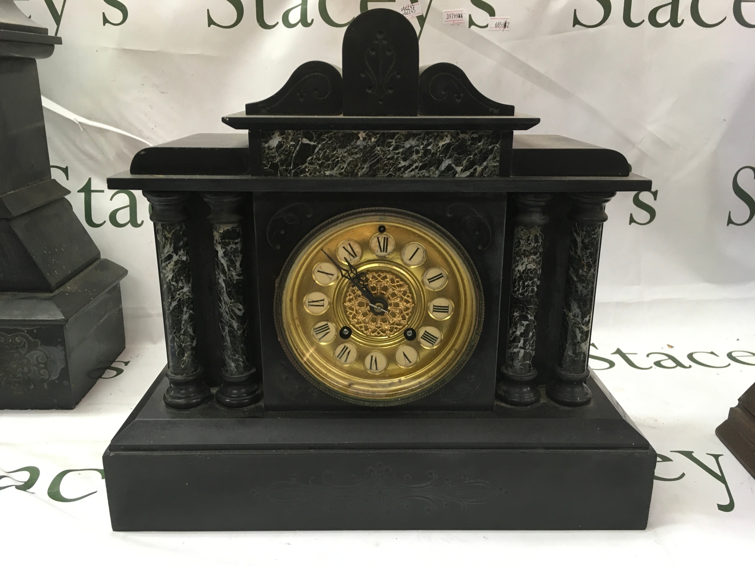 An antique mantle clock, from the late 19th century. It features a black slate case decorated with faux green marble panels and columns, gilded brass dial with Roman numerals and is powered by an 8-day movement. Height 30cm. ( not working )