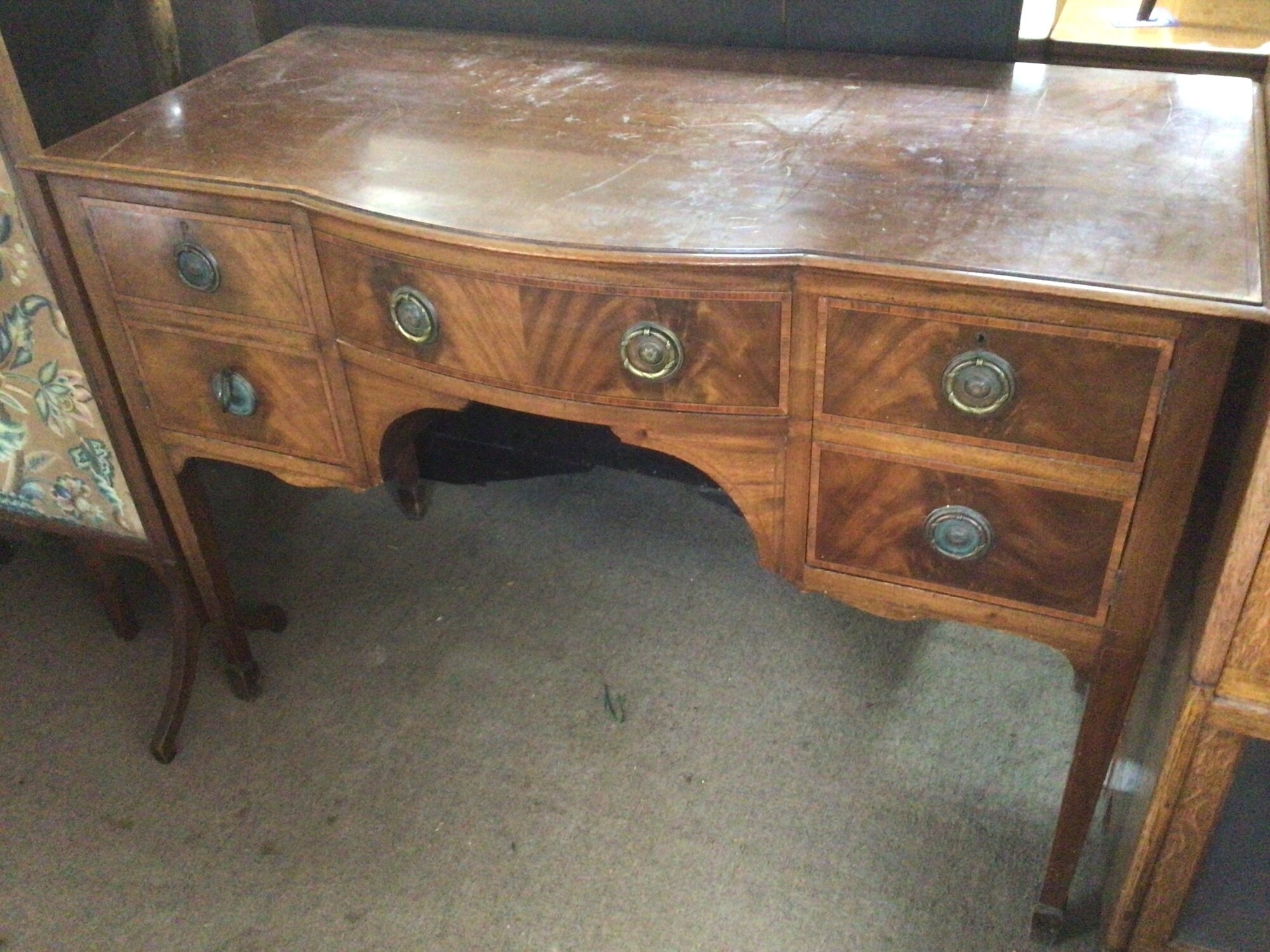 An Edwardian satinwood banded mahogany sideboard fitted with four drawers with a shaped front on square tapering legs. TO BE SOLD WITHOUT RESERVE