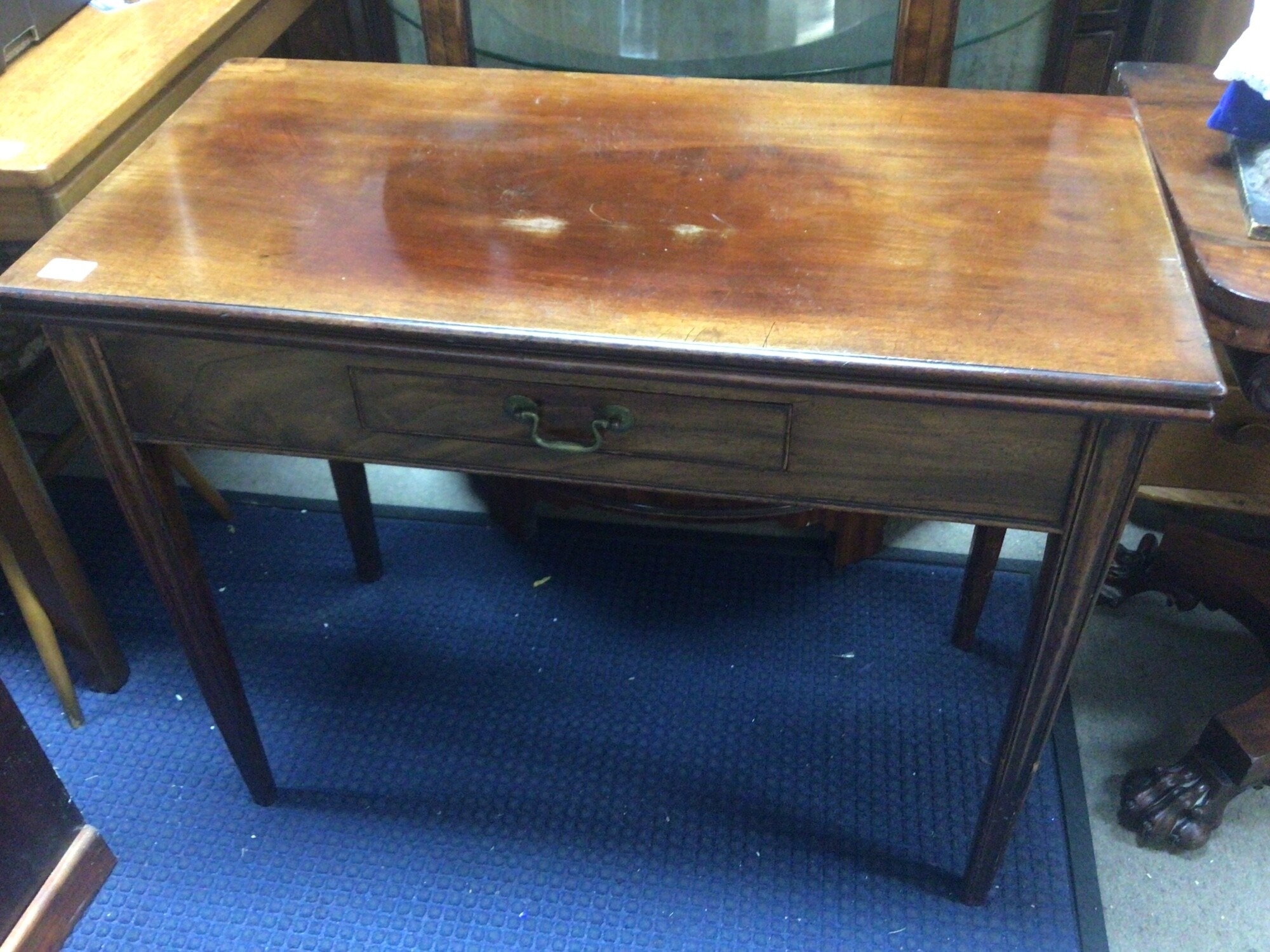 A George III mahogany tea table the twin flap top above a single drawer on square tapering legs. Width 90cm x 46cm