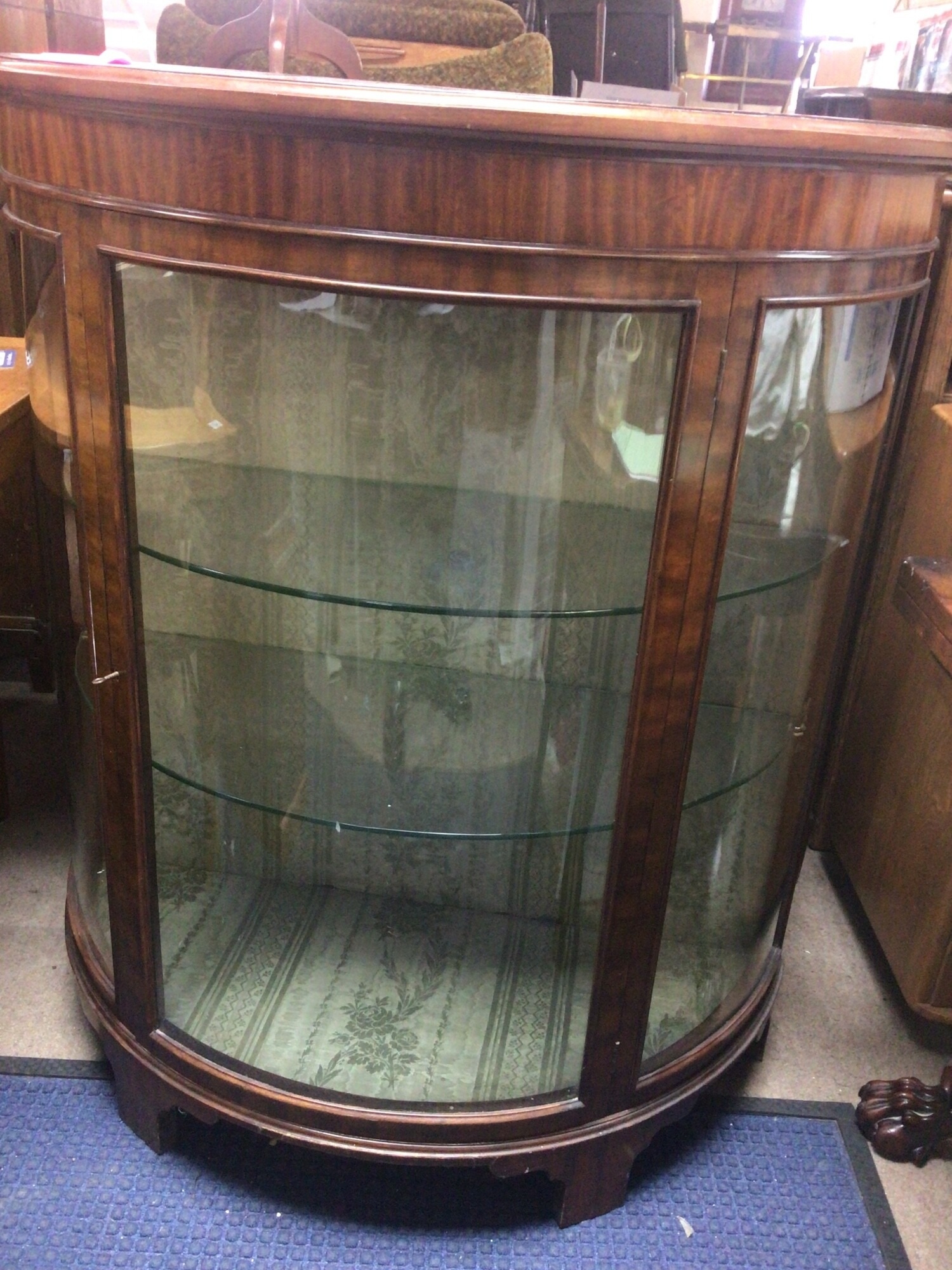 A quality Mahogany Early 20th century semi circular display cabinet with glass shelves on bracket feet good condition in keeping with age.