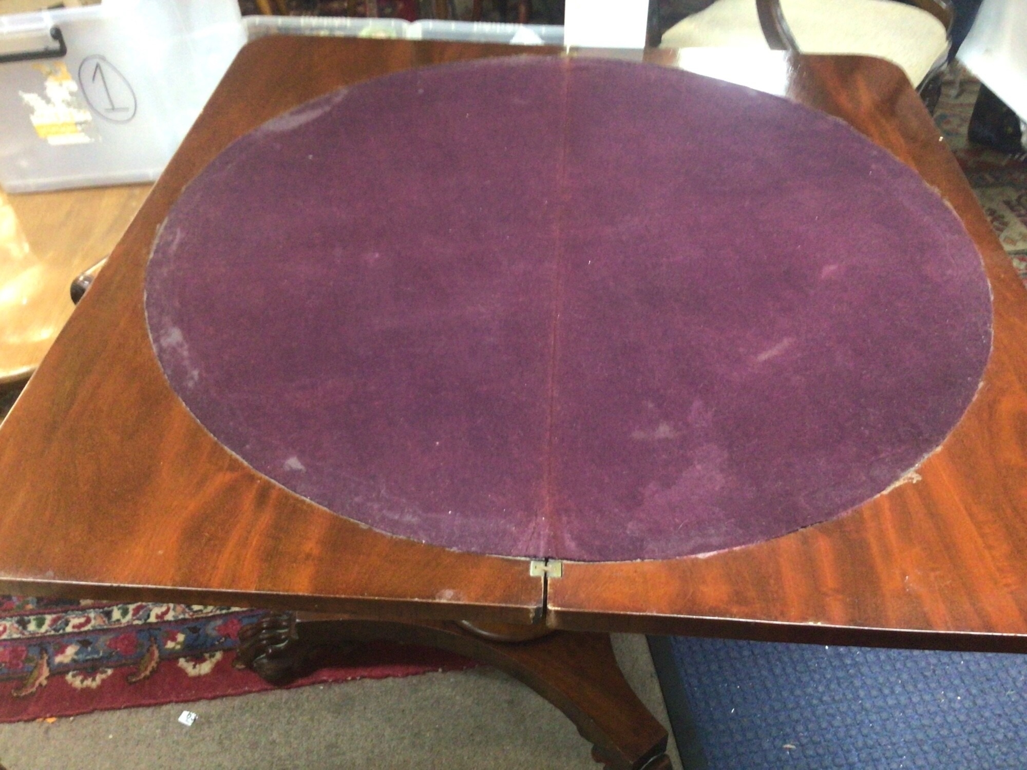 A Victorian Mahogany Card table the twin flap top above a shaped frieze with applied mouldings on a circular column