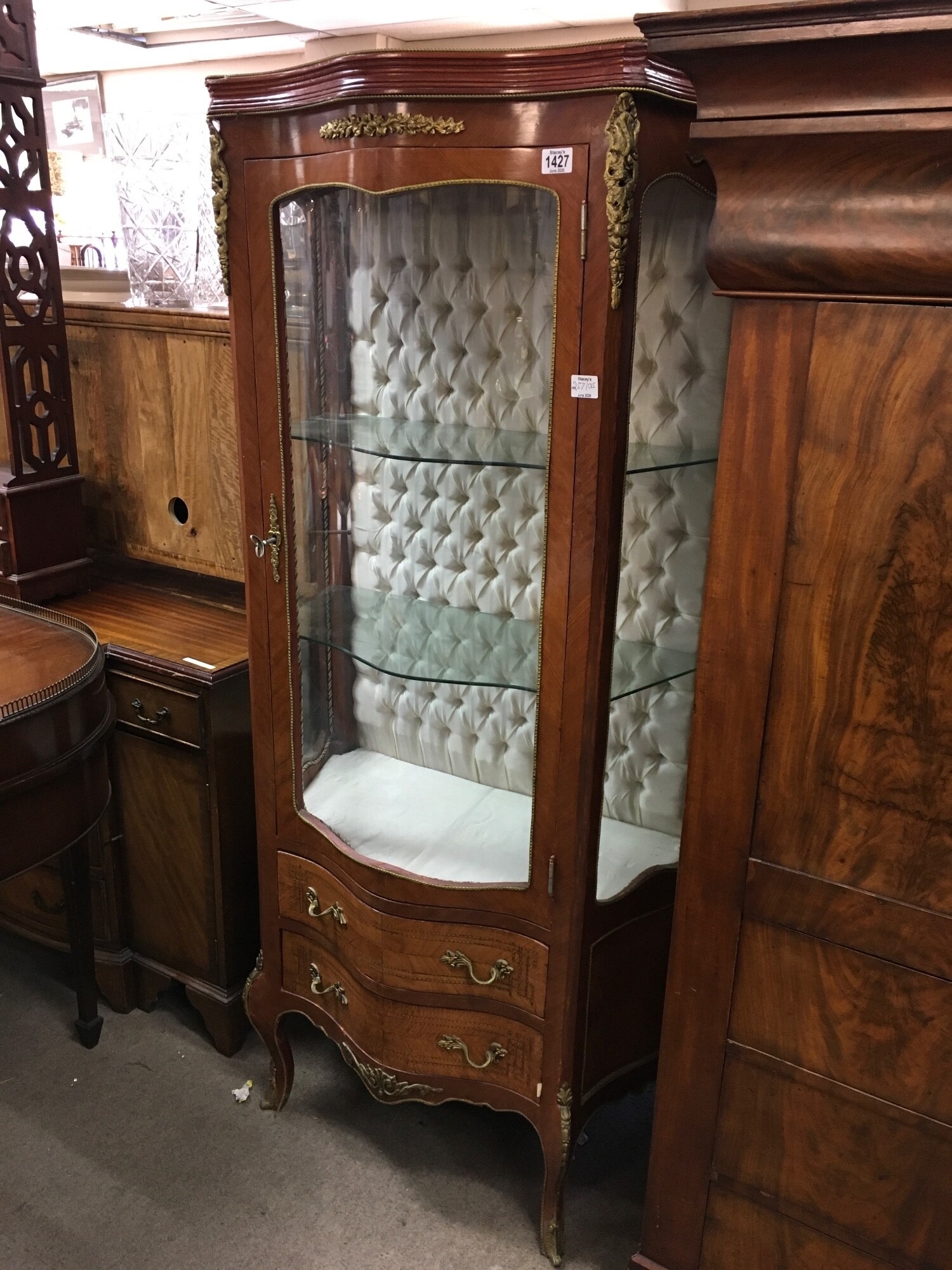 A French style display cabinet with single drawer and two drawers under, having cabriolet legs and gilt metal mounts