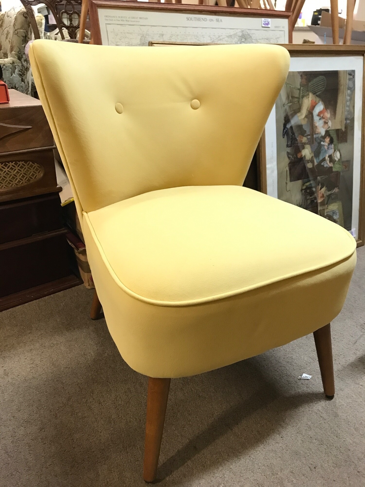 Mid 20th century design yellow velvet cocktail chair featuring a distinctively curved backrest with two button tufts and splayed wooden legs. 61cm wide 80cm tall 58cm long TO BE SOLD WITHOUT RESERVE