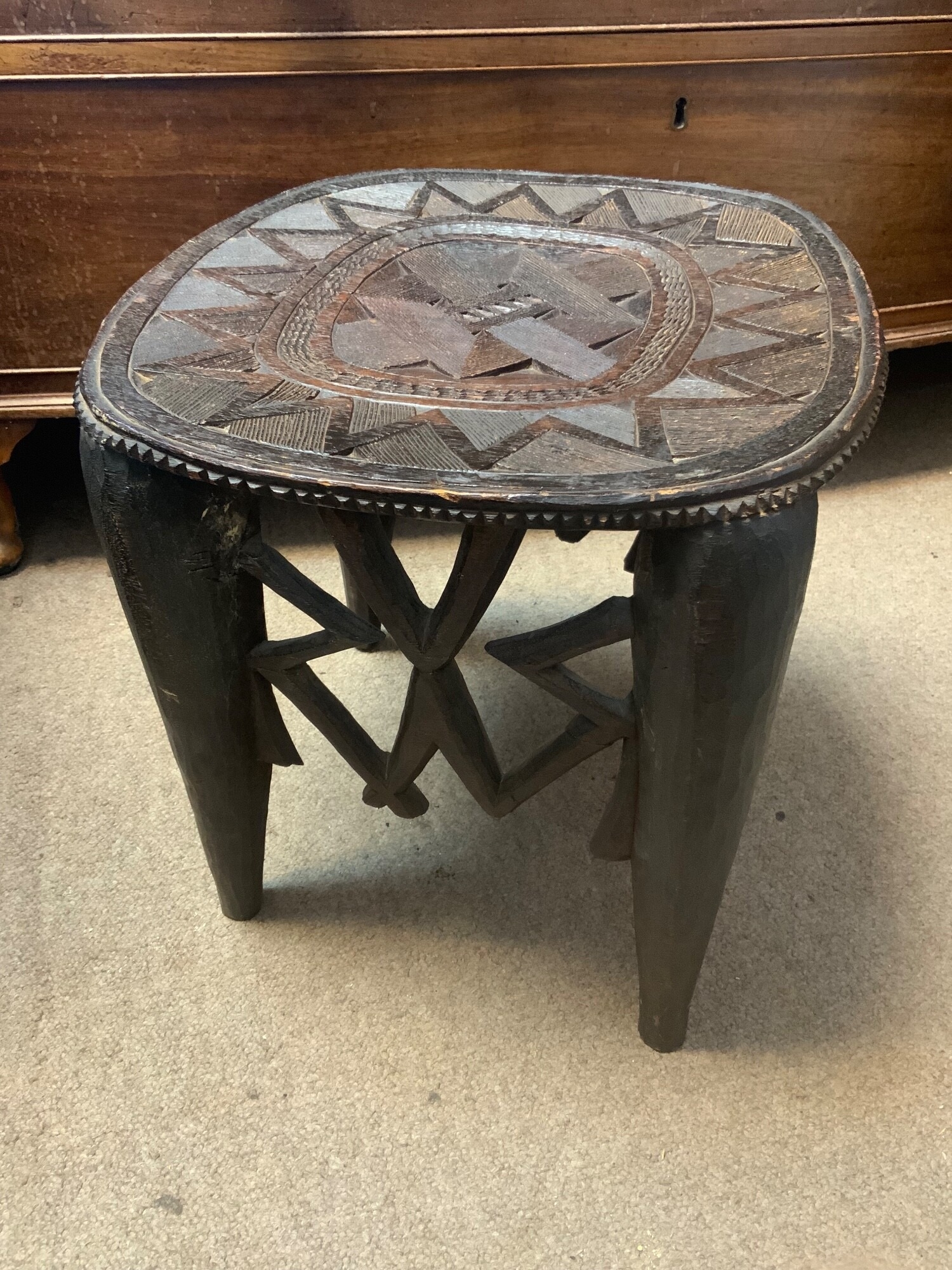 A vintage hand carved Nupe stool from Nigeria with intricate geometric patterns 15" High, together with a hand carved paddle.