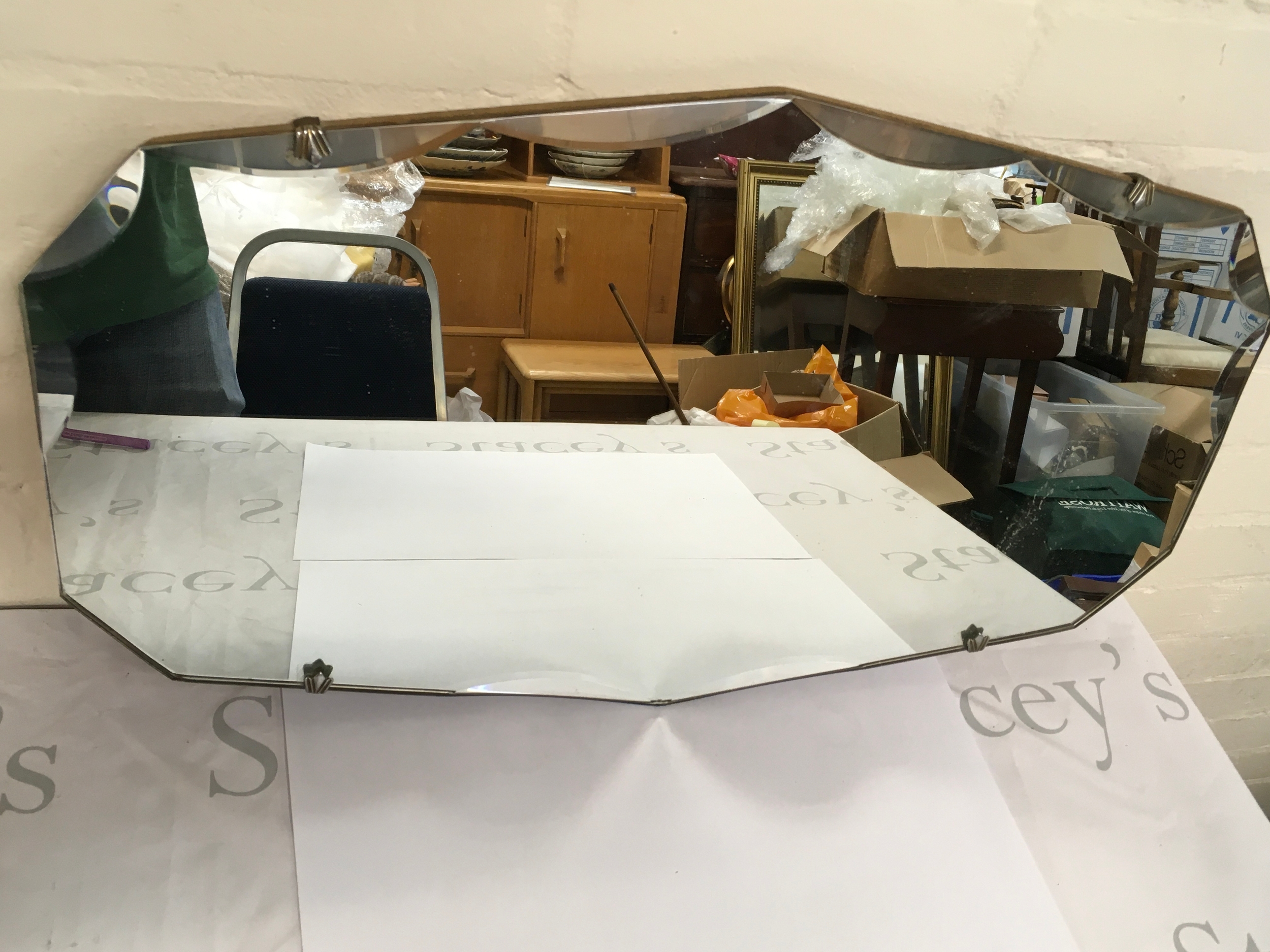 A large oval mirror with scalloped edges. 66cm by 38cm 