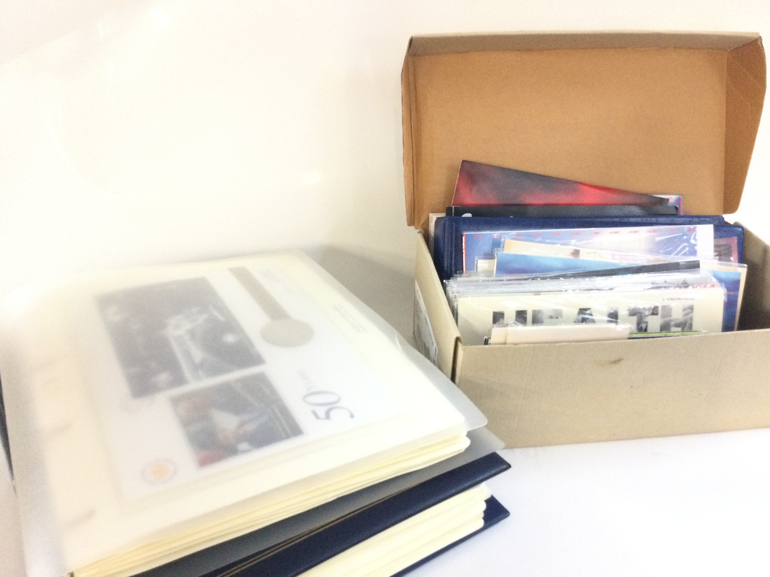 A shoe box of mixed presentation stamp packs, first day covers etc, together with two albums of coin covers