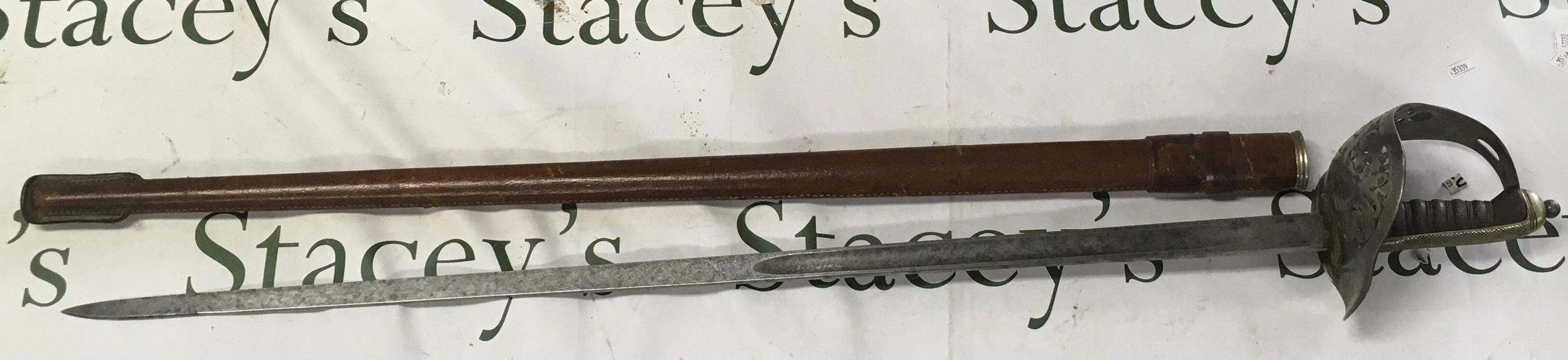 A George V inventory officers steel hilt with royal cypher the blade with conforming etched pattern. Leather covers scabbard. 
