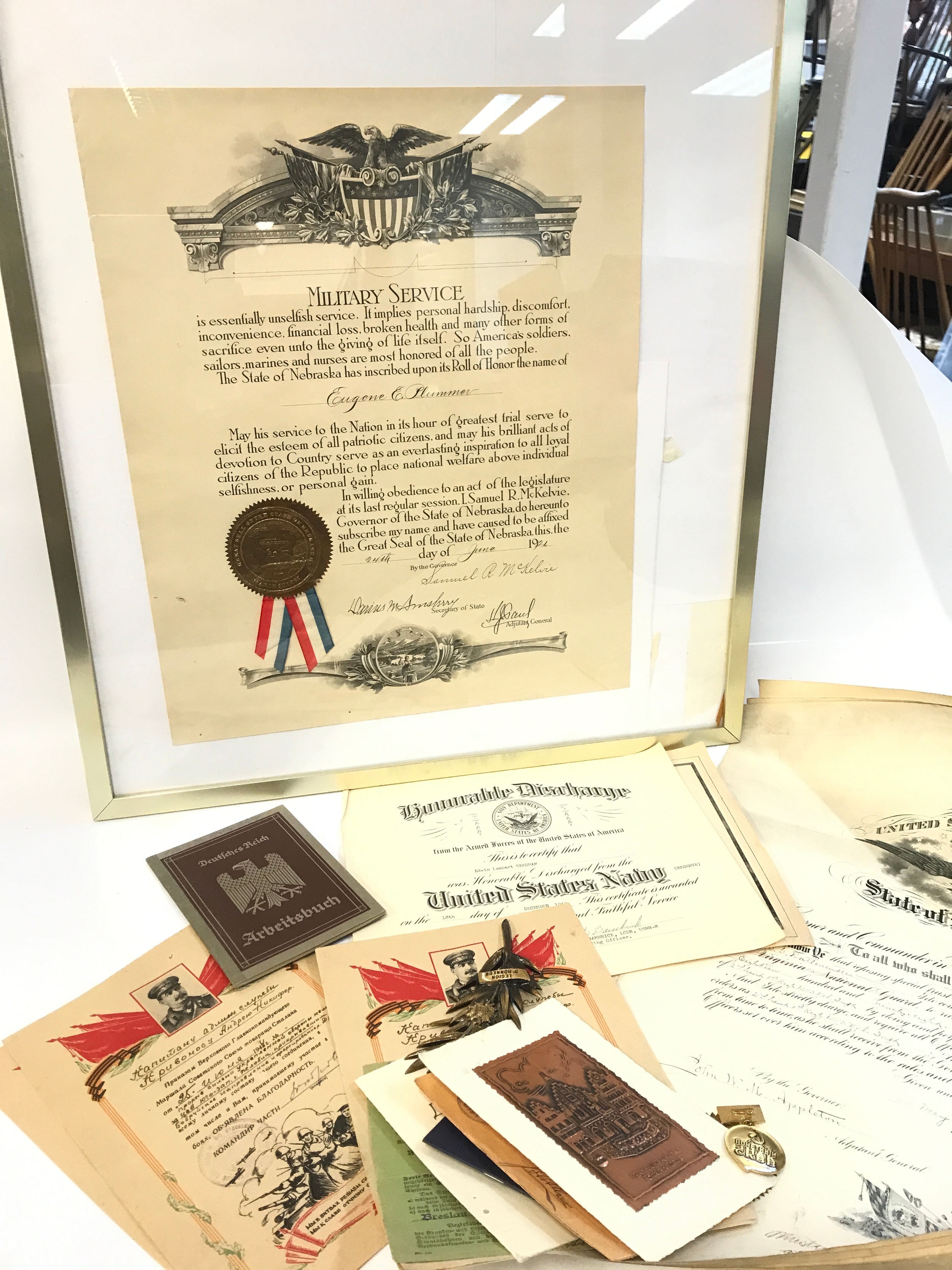 A collection of military items including records of service from the USA, Russia, German Reich work book, Palme de la Légion d'honneur, Honorary Badge of the Soviet Committee of War Veterans