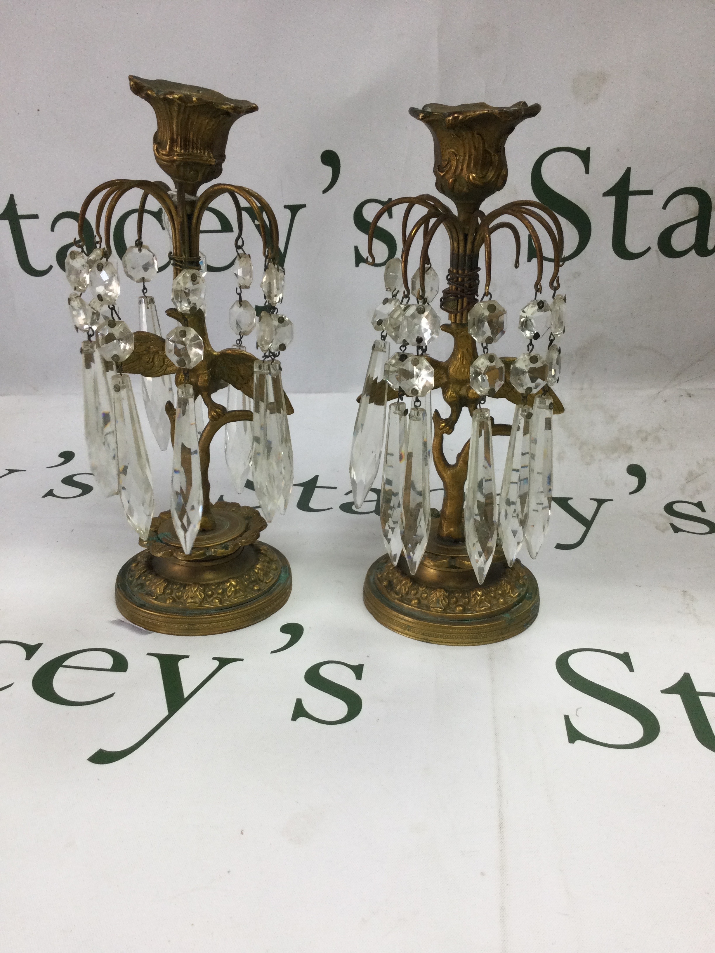 Pair of vintage brass and cut glass lustre candlesticks. A matching pair of candlesticks in traditional regency/Edwardian style. Polished gilt-brass frames with embossed detailing, fitted with with hanging faceted crystal drops. Has some missing hanging crystal drops