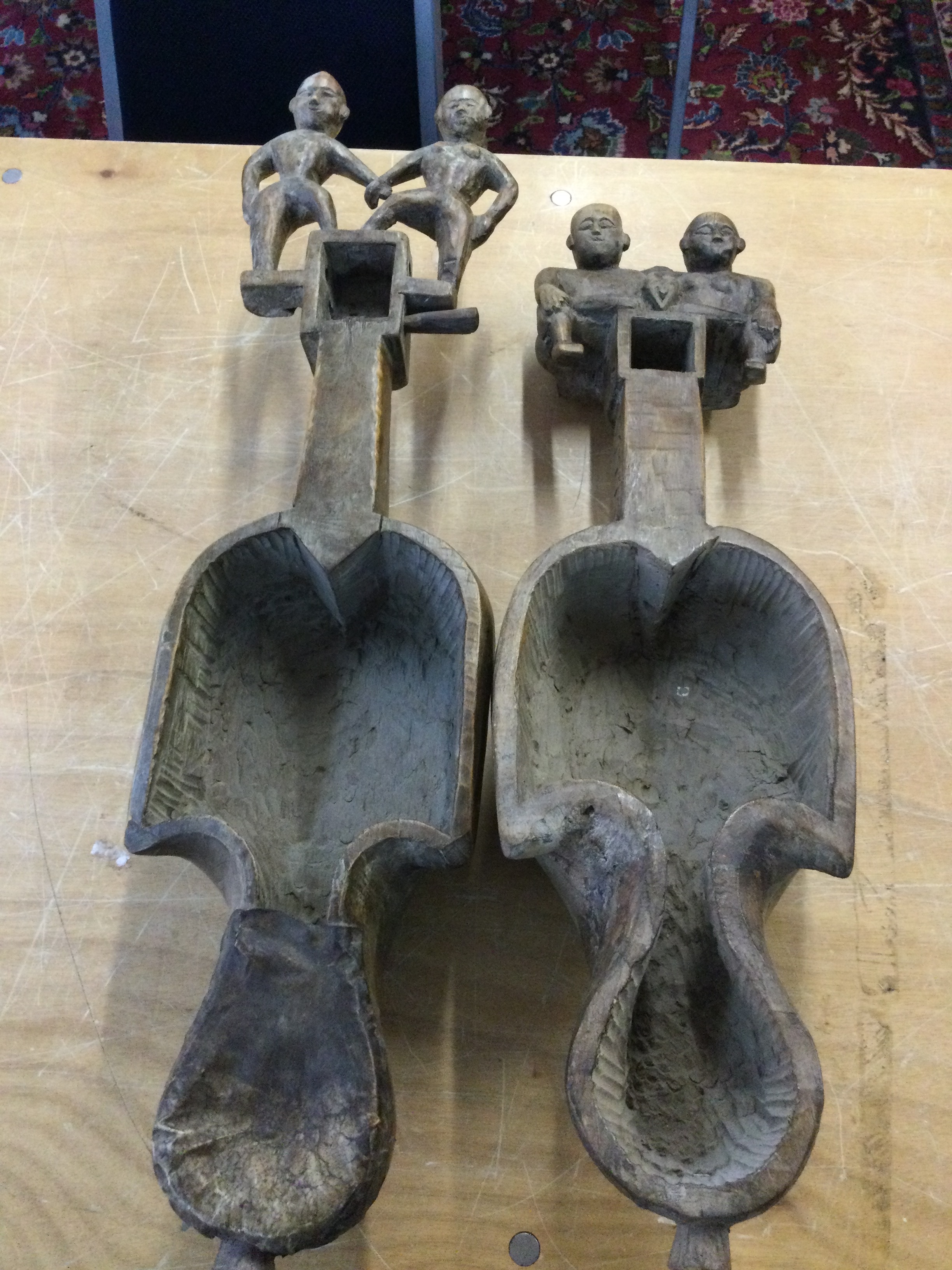 Two traditional hand-carved Nepali Sarangi musical instruments, with ornate figures carved into the pegbox. 66cm long 