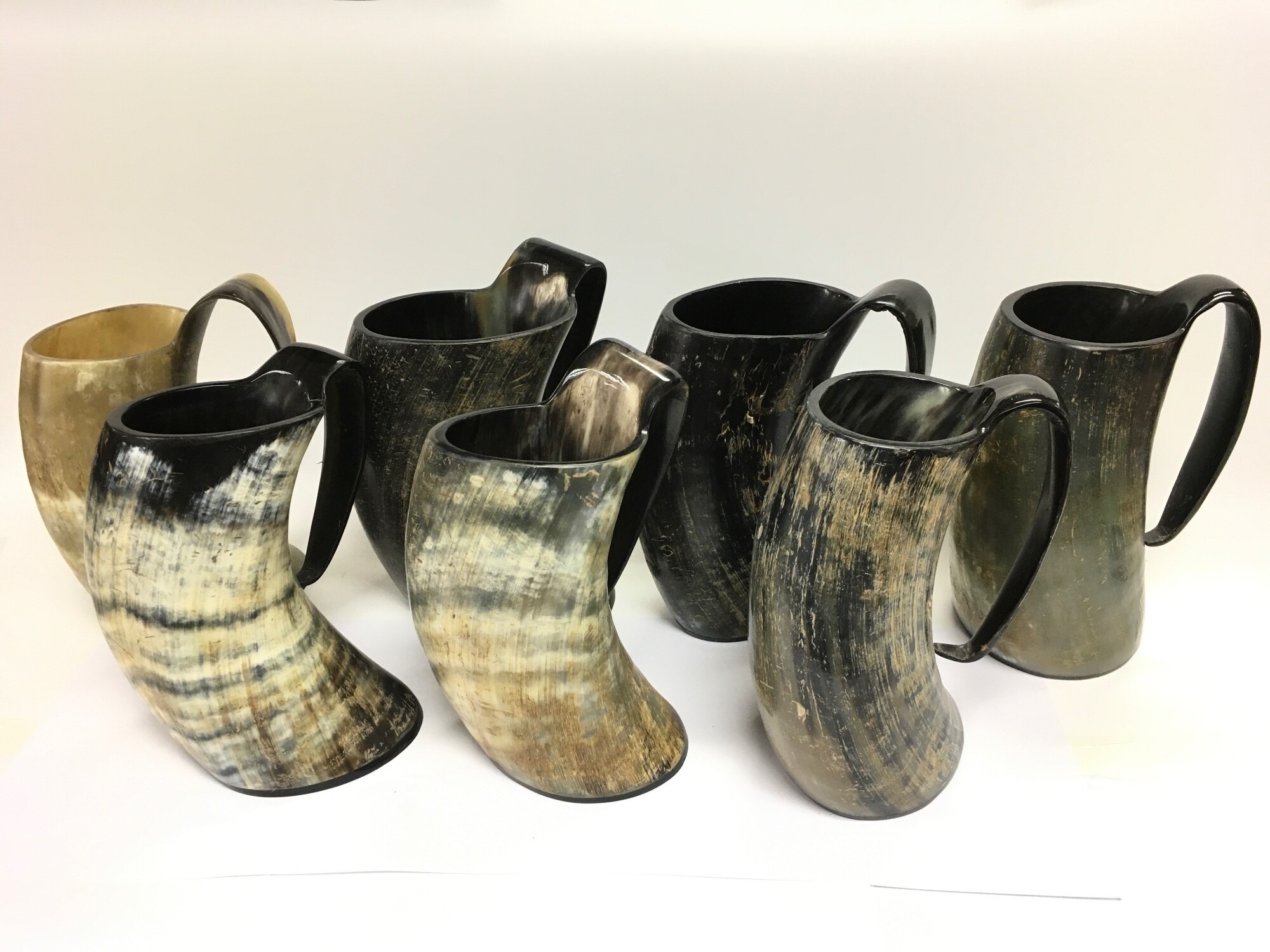 Seven cow horn tankards, approx height 23cm.