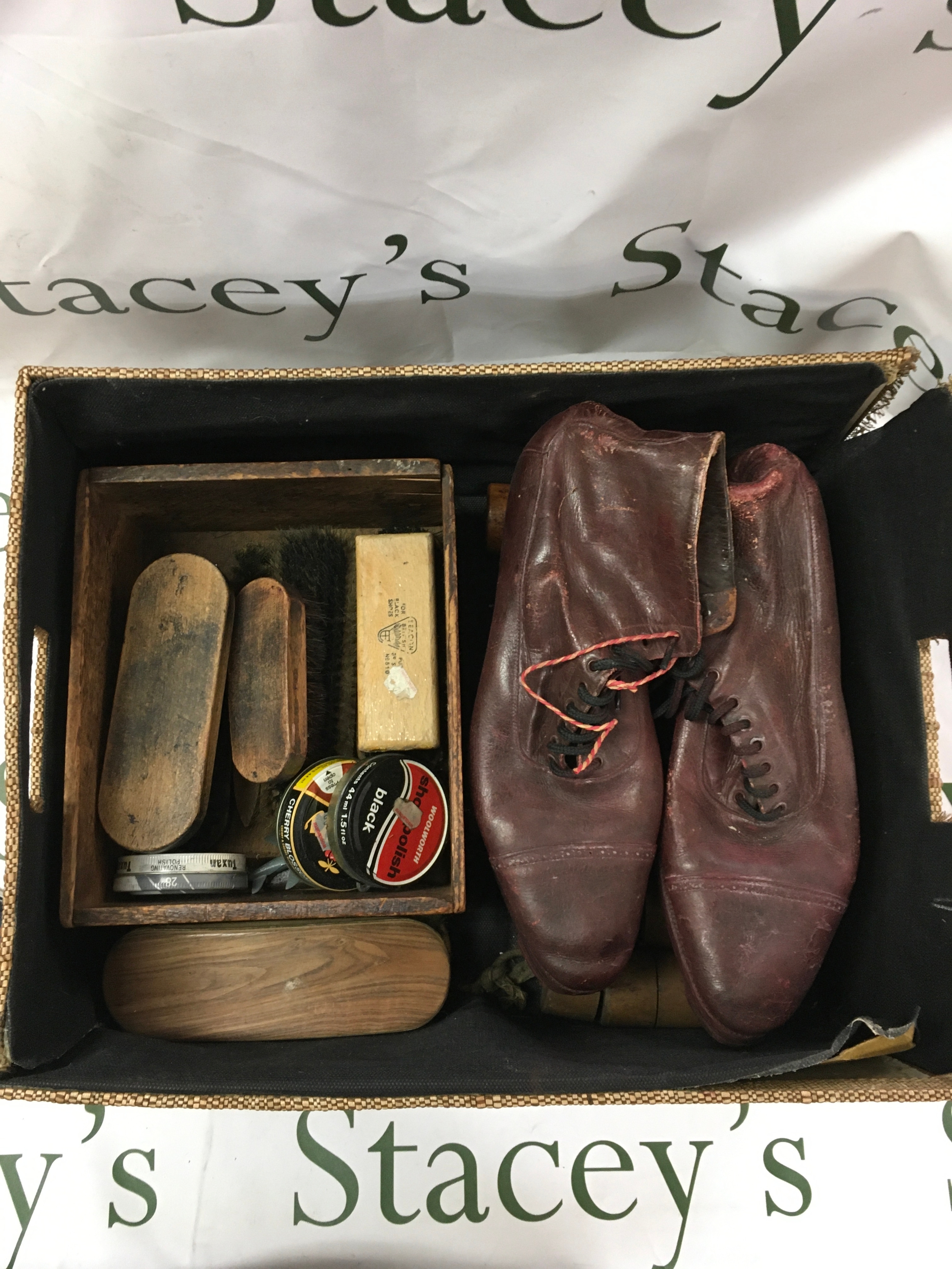 A vintage shoe care collection featuring shoe shine caddy, polishes and brushes, footwear, and shoe forms. 