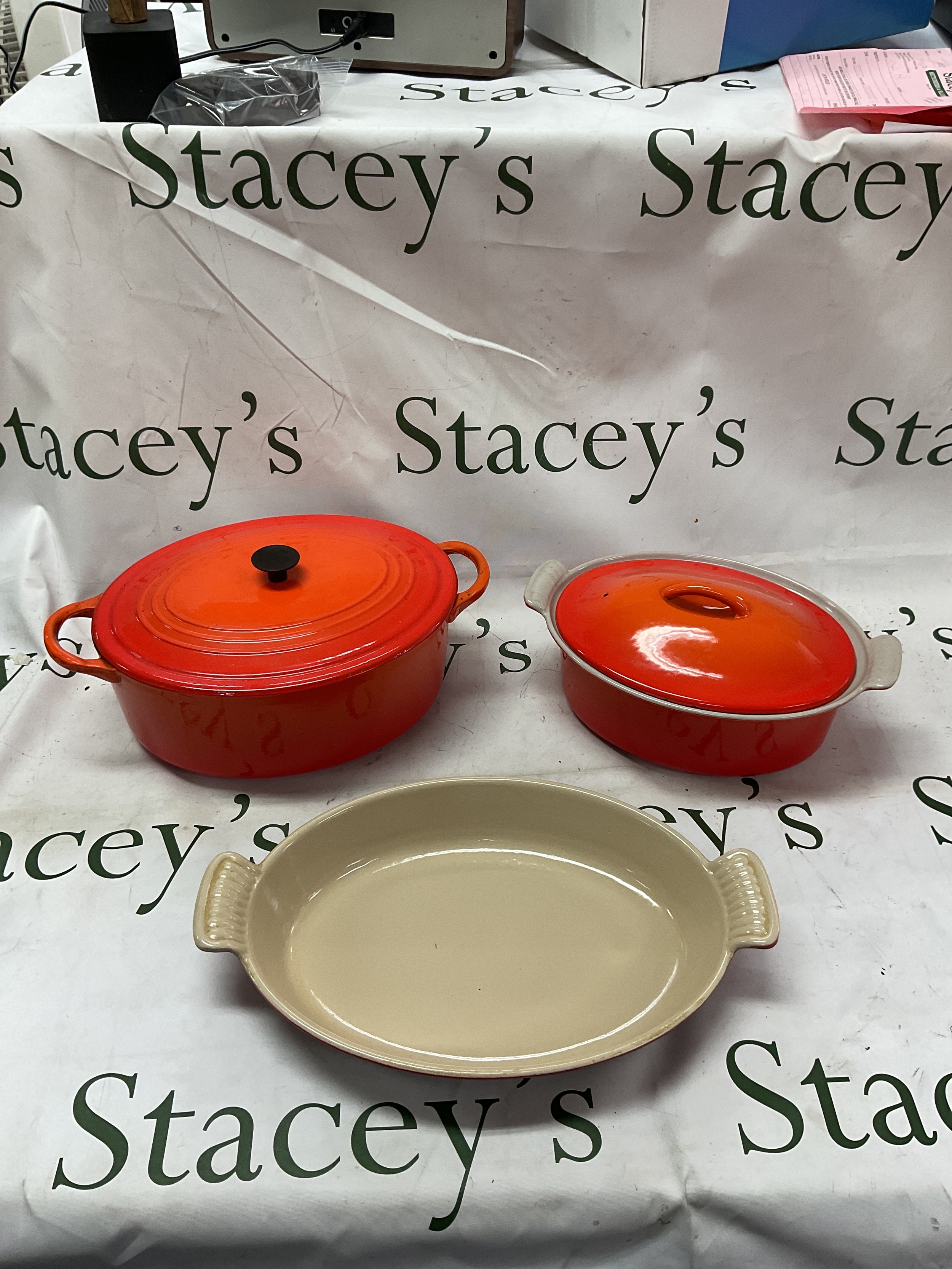 Three Le Creuset items , two casserole lidded dishes and an open lidded example.