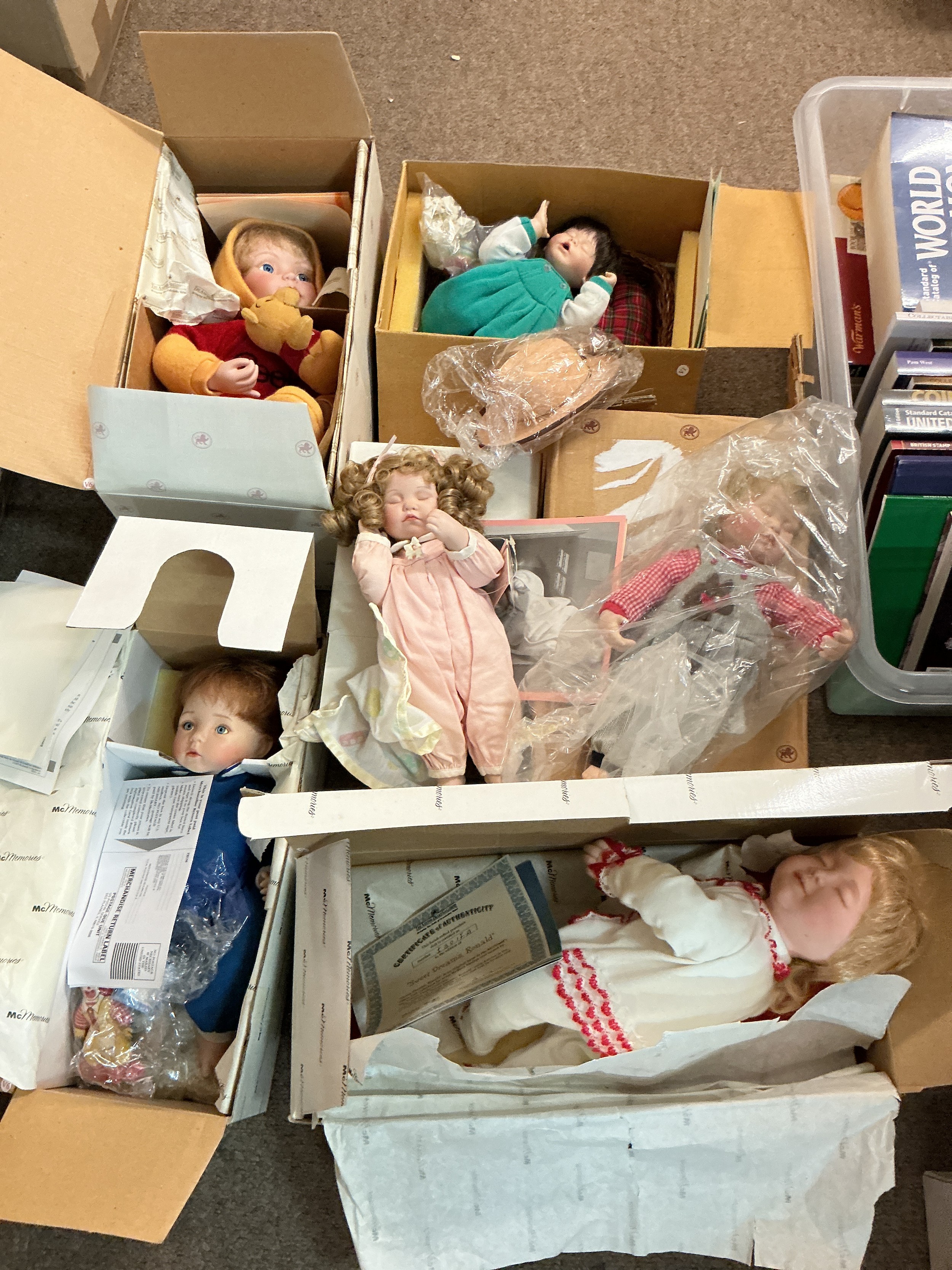 A collection of boxed Ashton Drake life like dolls.