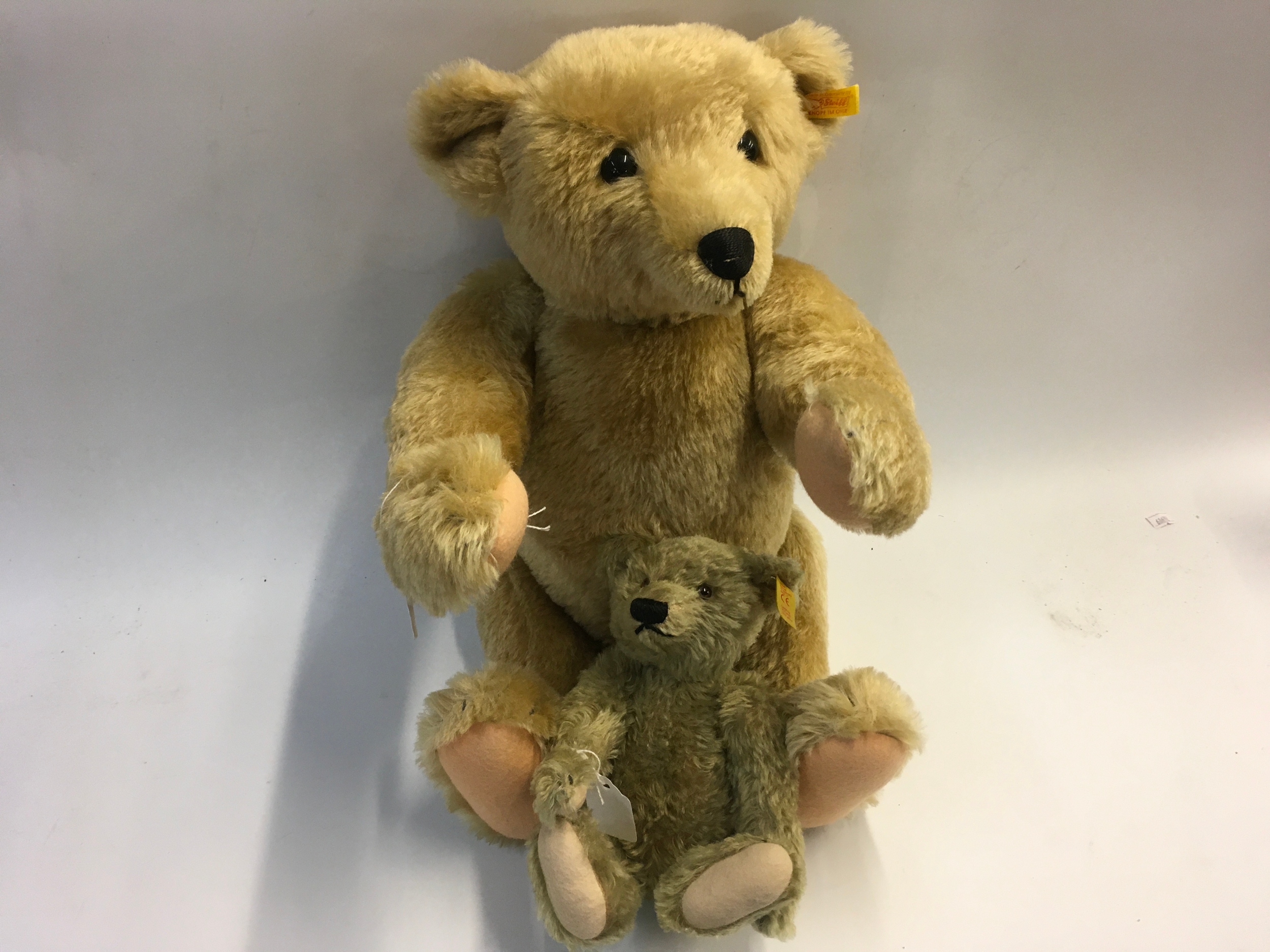 Two Steiff bears (a plush mohair articulated humped back bear with growler, small articulated bear, both with buttons in ear)