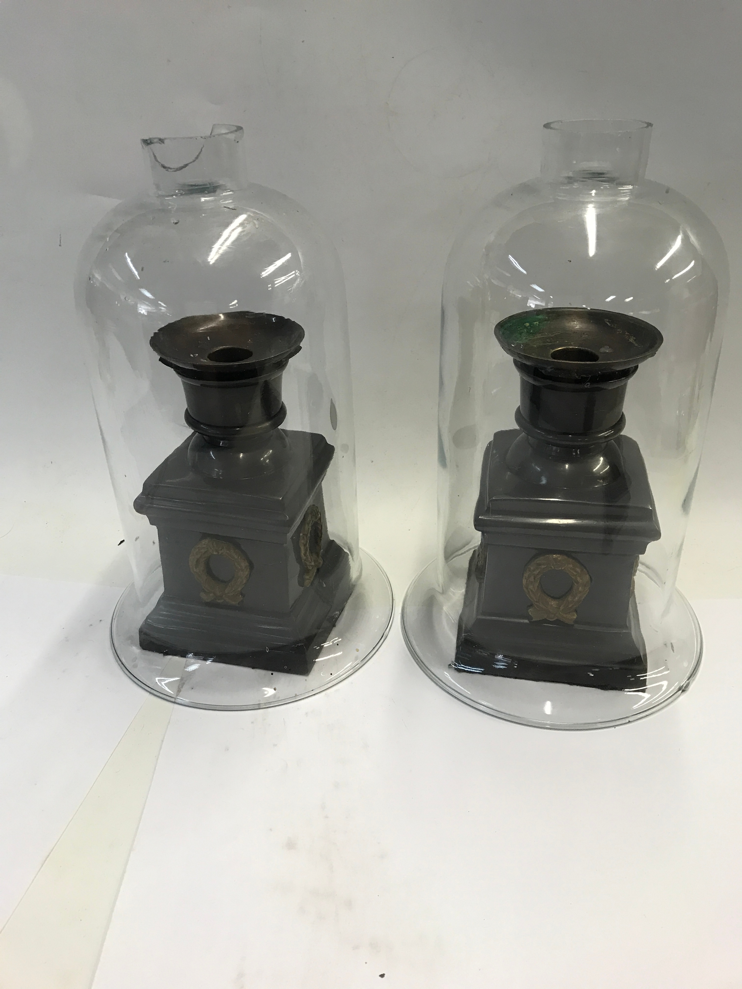 A pair of hurricane candle holders with glass shades. 