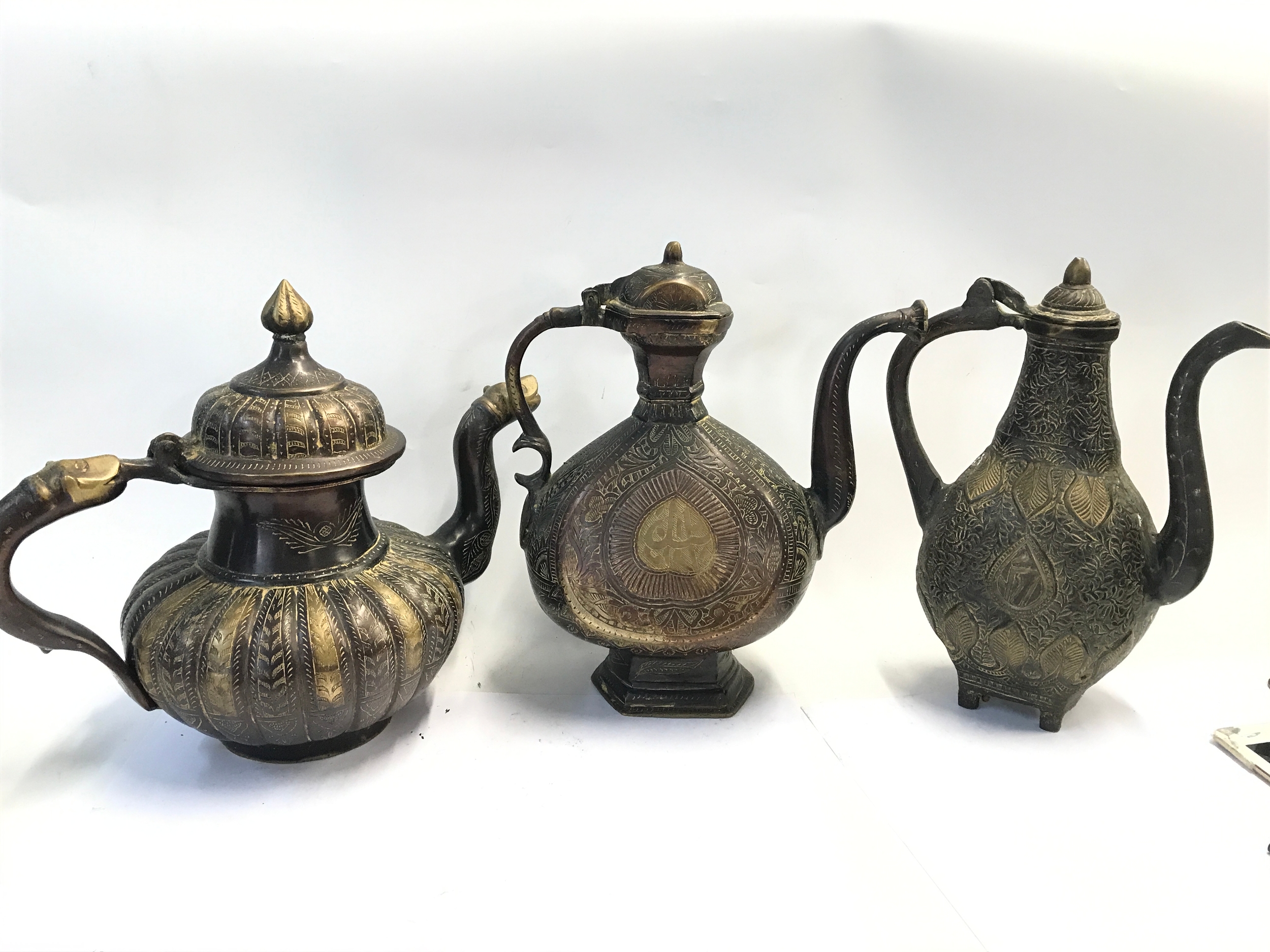 Three bronze ewers. 29 to 31cm tall