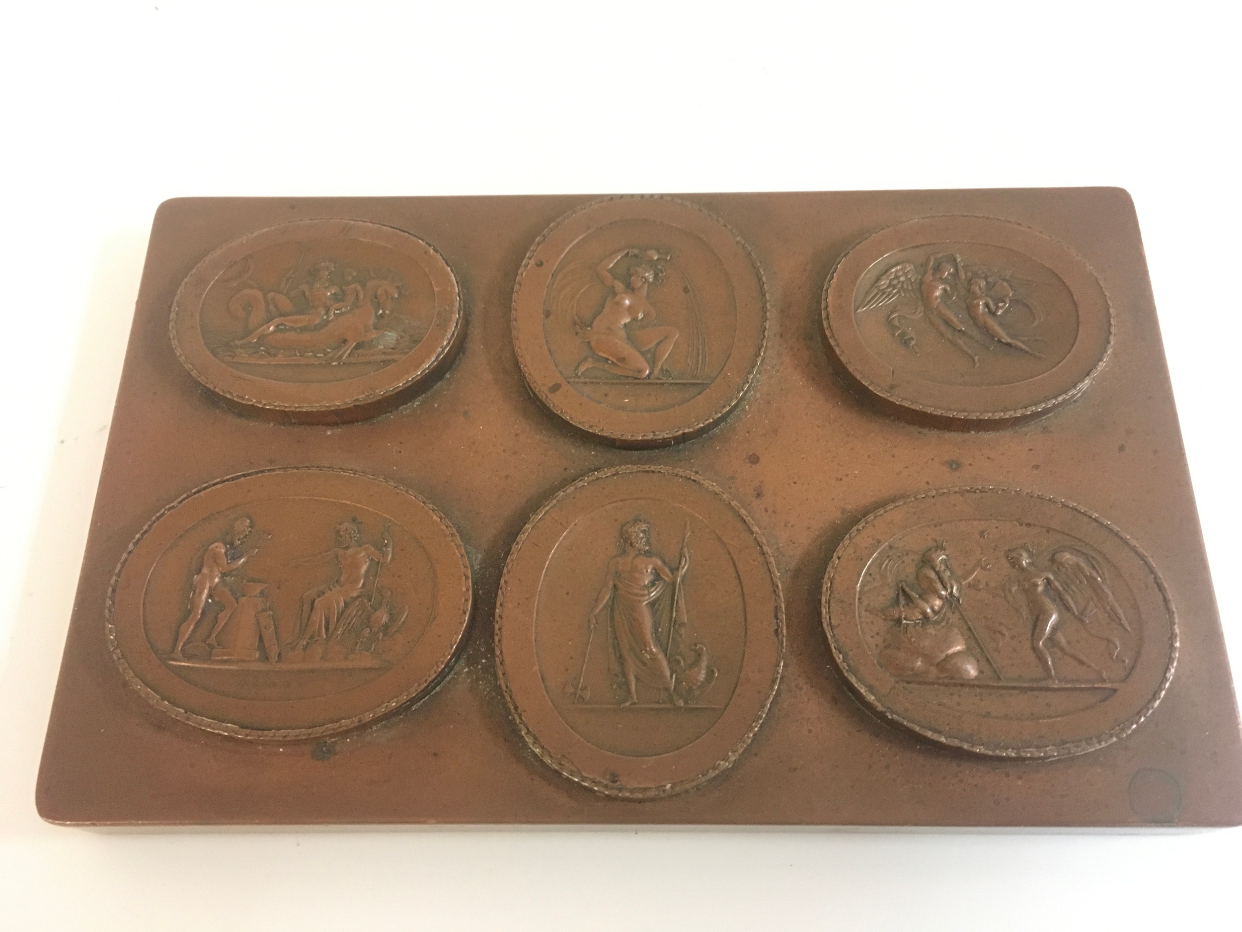 A bronze plaque featuring six distinct relief medallions depicting mythical gods 16x10cm. No reserve