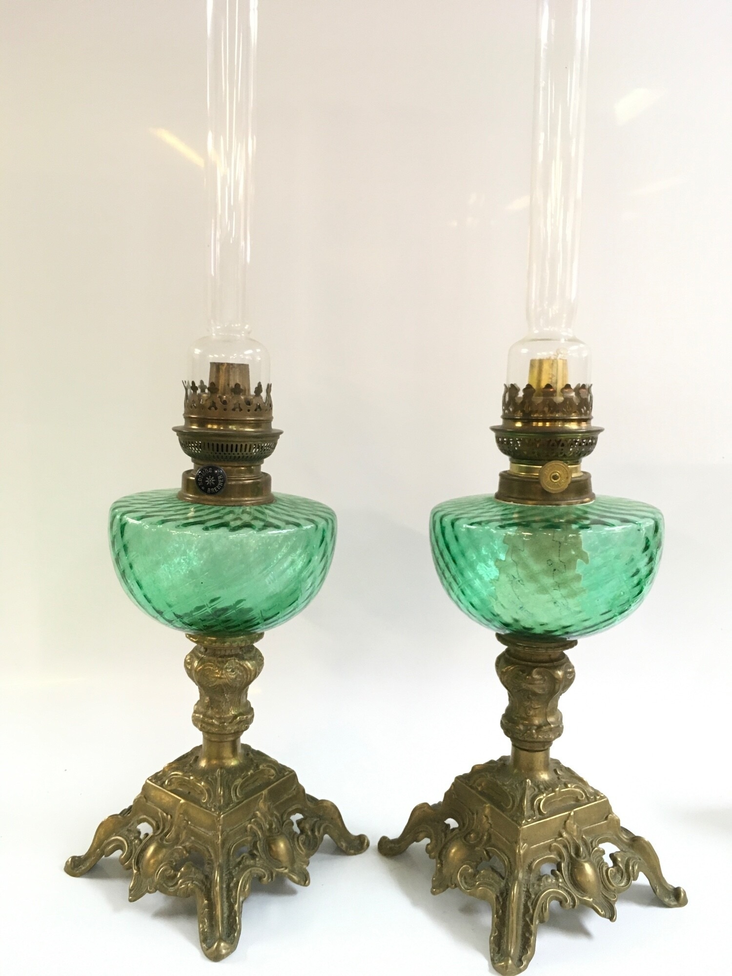 Two early 20th century oil lamps with green glass fonts and ornate brass bases, with Kosmos Brenner style burners. 56cm tall NO RESERVE